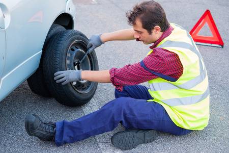 Man Changing A Flat Tyre After Vehicle Breakdown Stock Photo, Picture And  Royalty Free Image. Image 85193264.